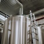 a steel ladder leaning on stainless steel tank