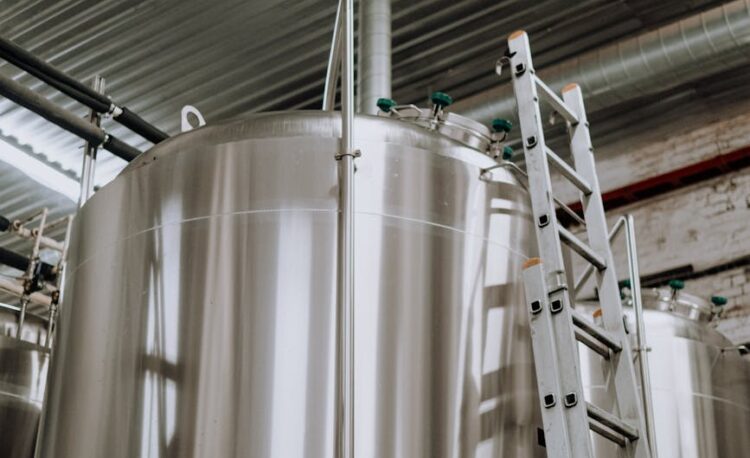 a steel ladder leaning on stainless steel tank