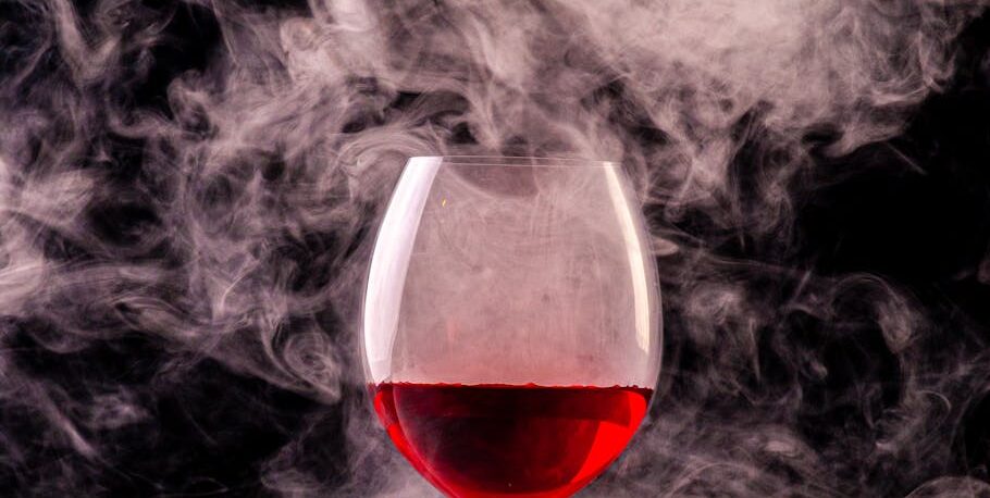 close up shot of a glass of red wine with smoke effect